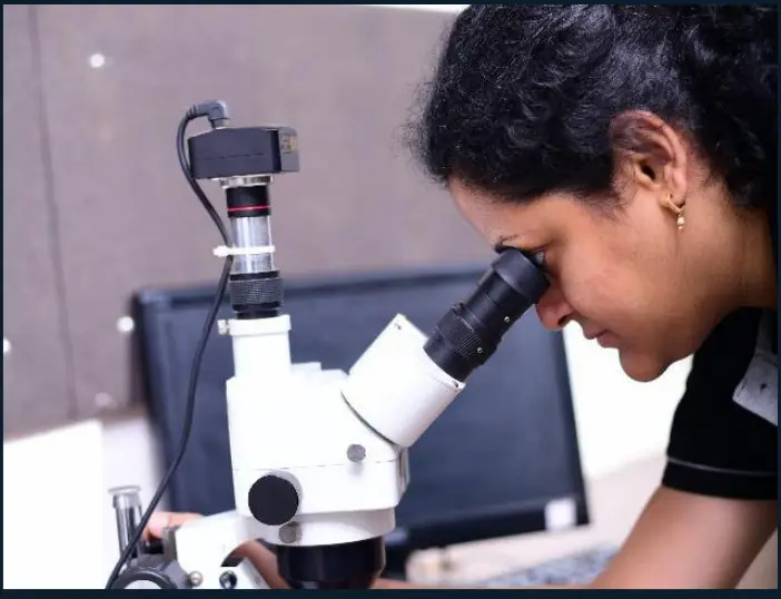 A TCR Advanced metallurgist reading a microstructure on a stereo microscope