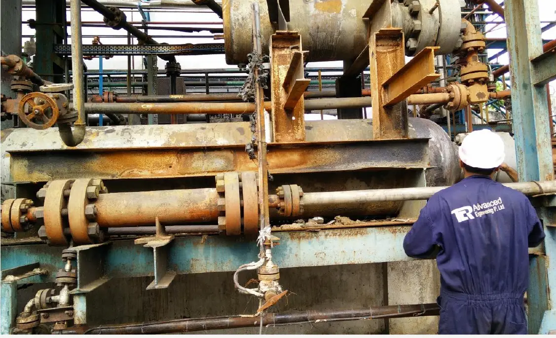 A TCR Advanced field inspector beside heavily corroded piping found during an external corrosion survey