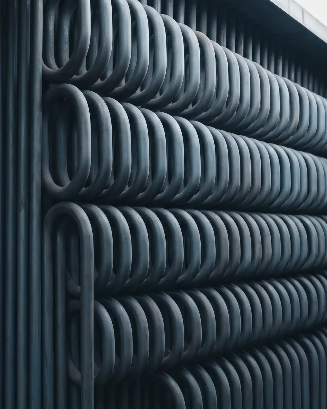 A dense bank of superheater tubes in cold monochrome