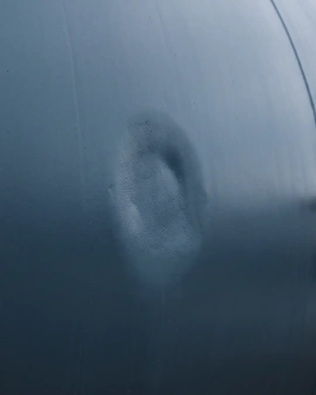 A curved pressure-vessel wall with a subtle metal-loss patch