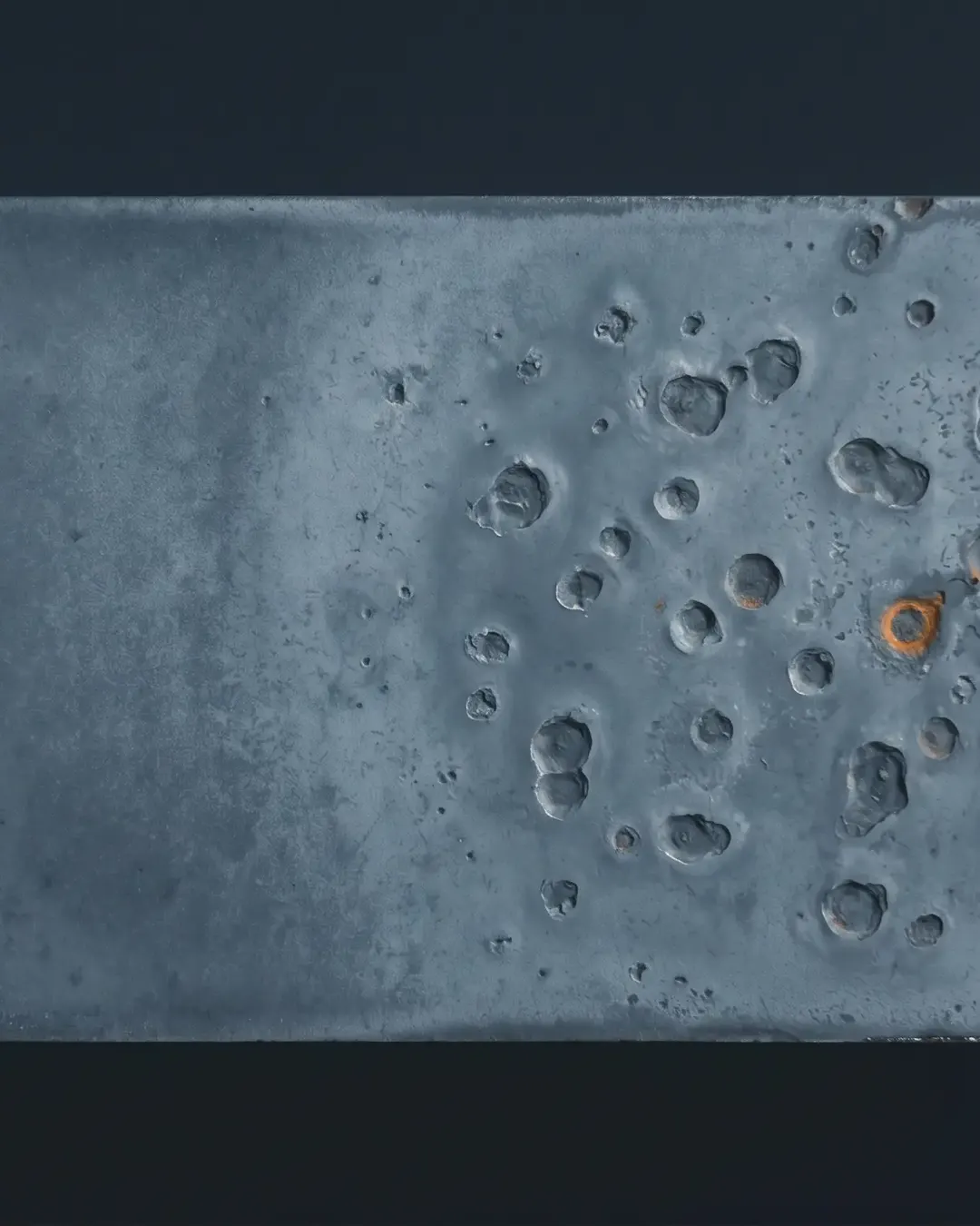Macro of a corrosion coupon face showing shallow pitting under cold light
