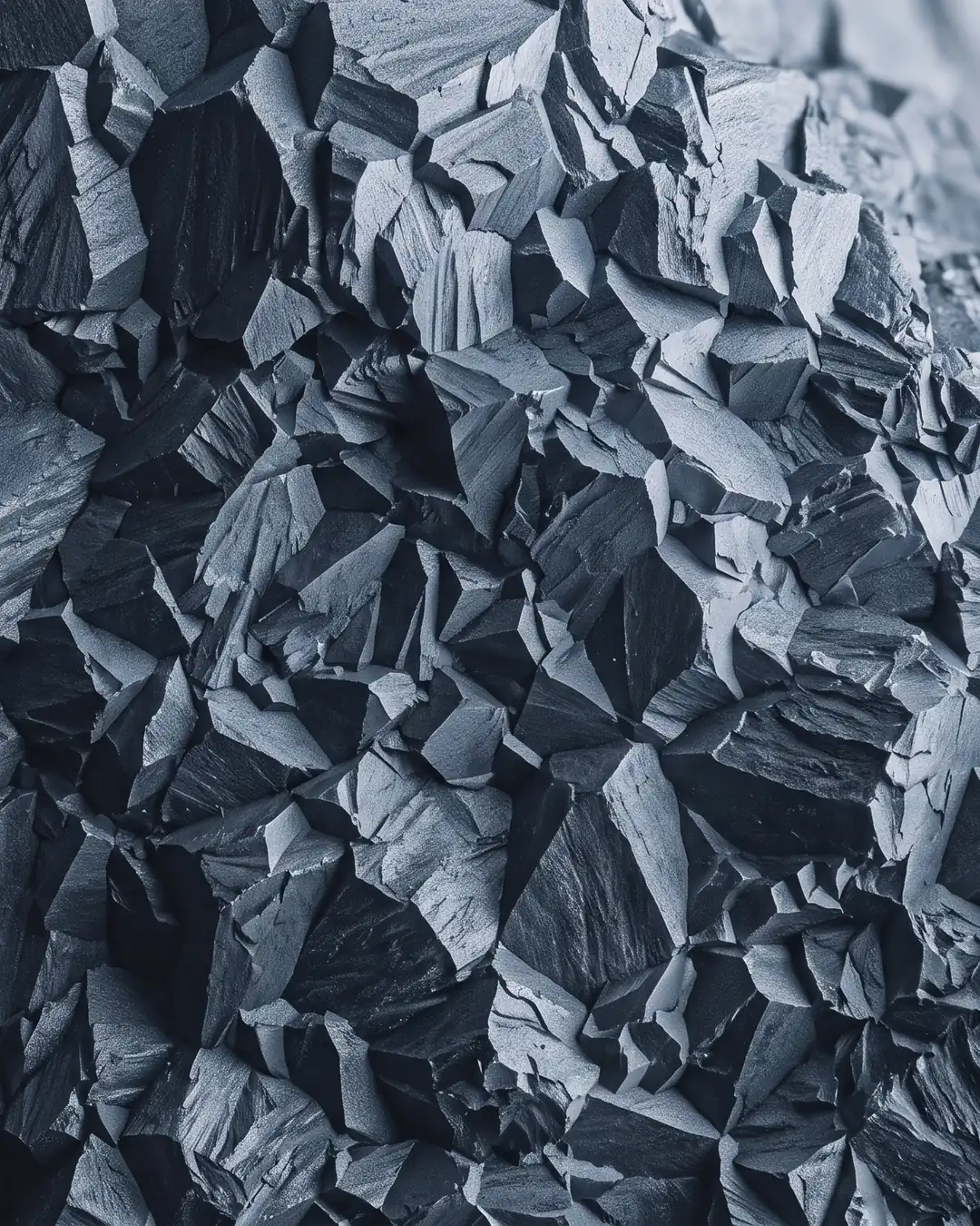 Macro view of a brittle steel fracture surface, its faceted intergranular grains catching low light