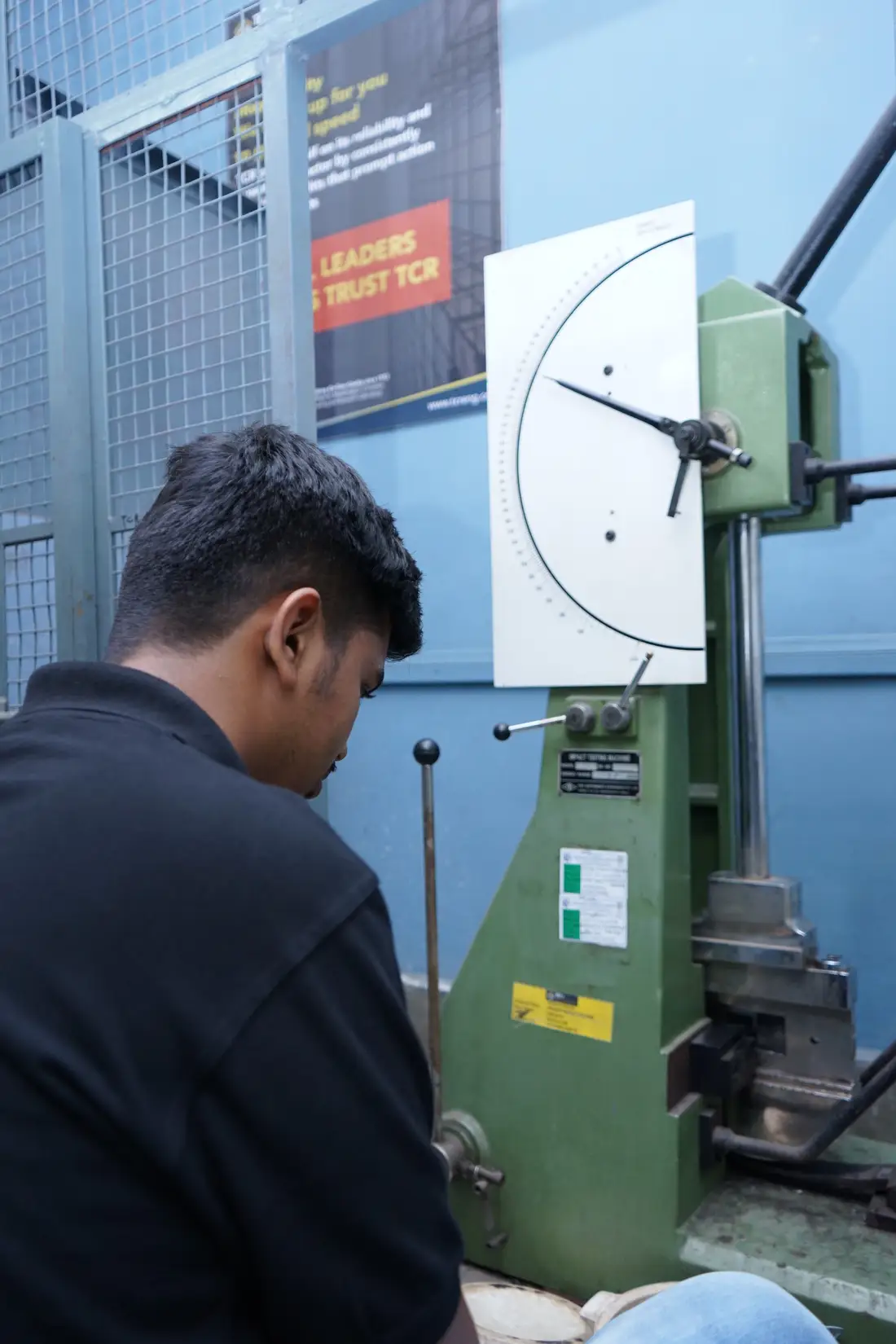 A Charpy pendulum impact tester at TCR Engineering with a notched specimen in the anvil