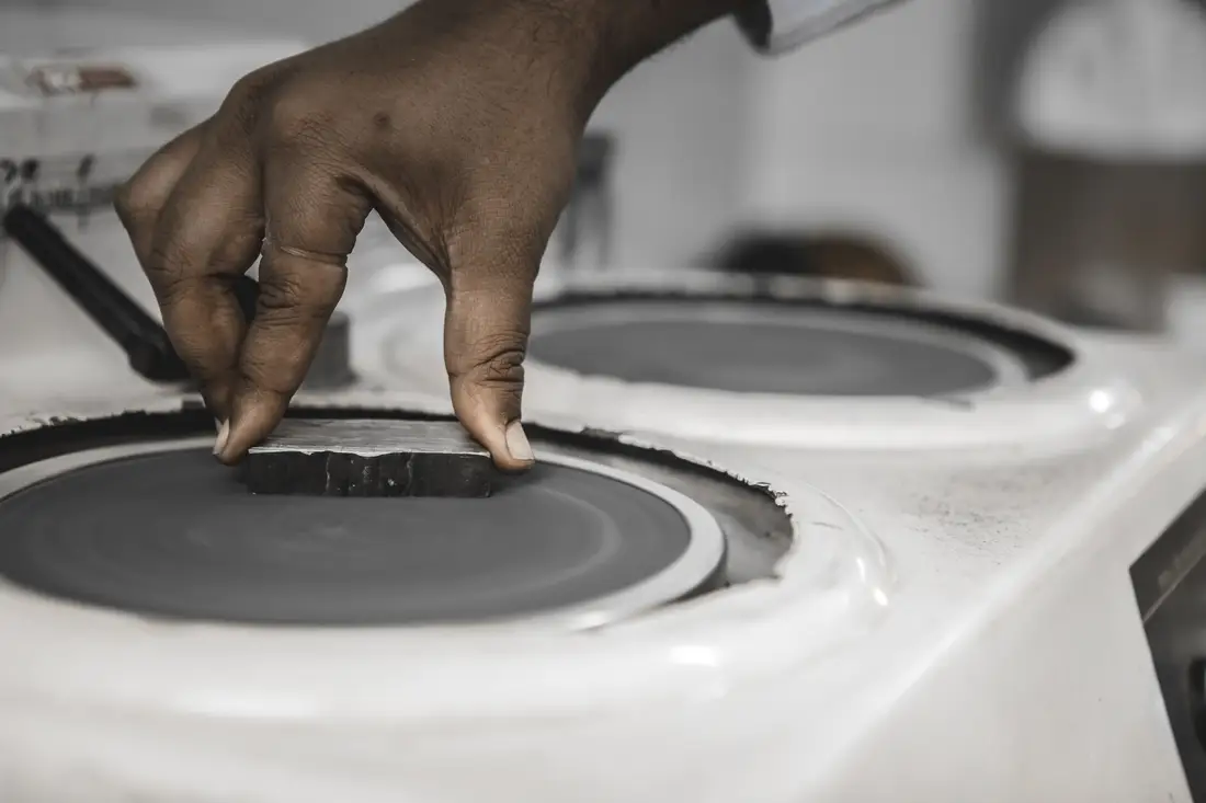 A metallographic specimen being polished on a rotating wheel before etching