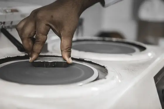 A metallographic specimen being polished on a rotating wheel before etching