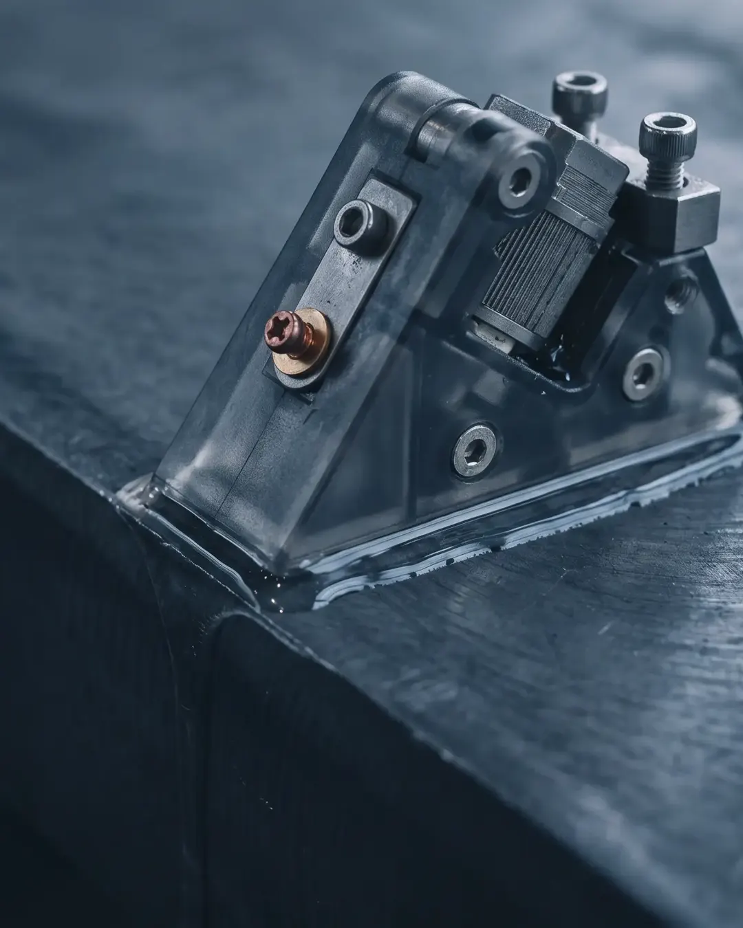 Macro of a phased-array ultrasonic probe wedge seated on a steel surface