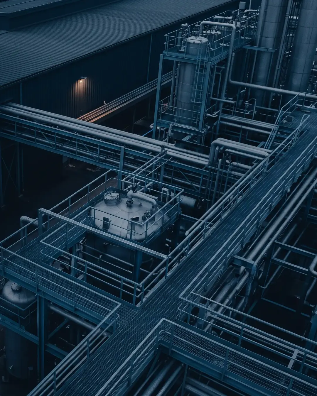 An overhead view of pipe racks and vessels at dusk reduced to geometry