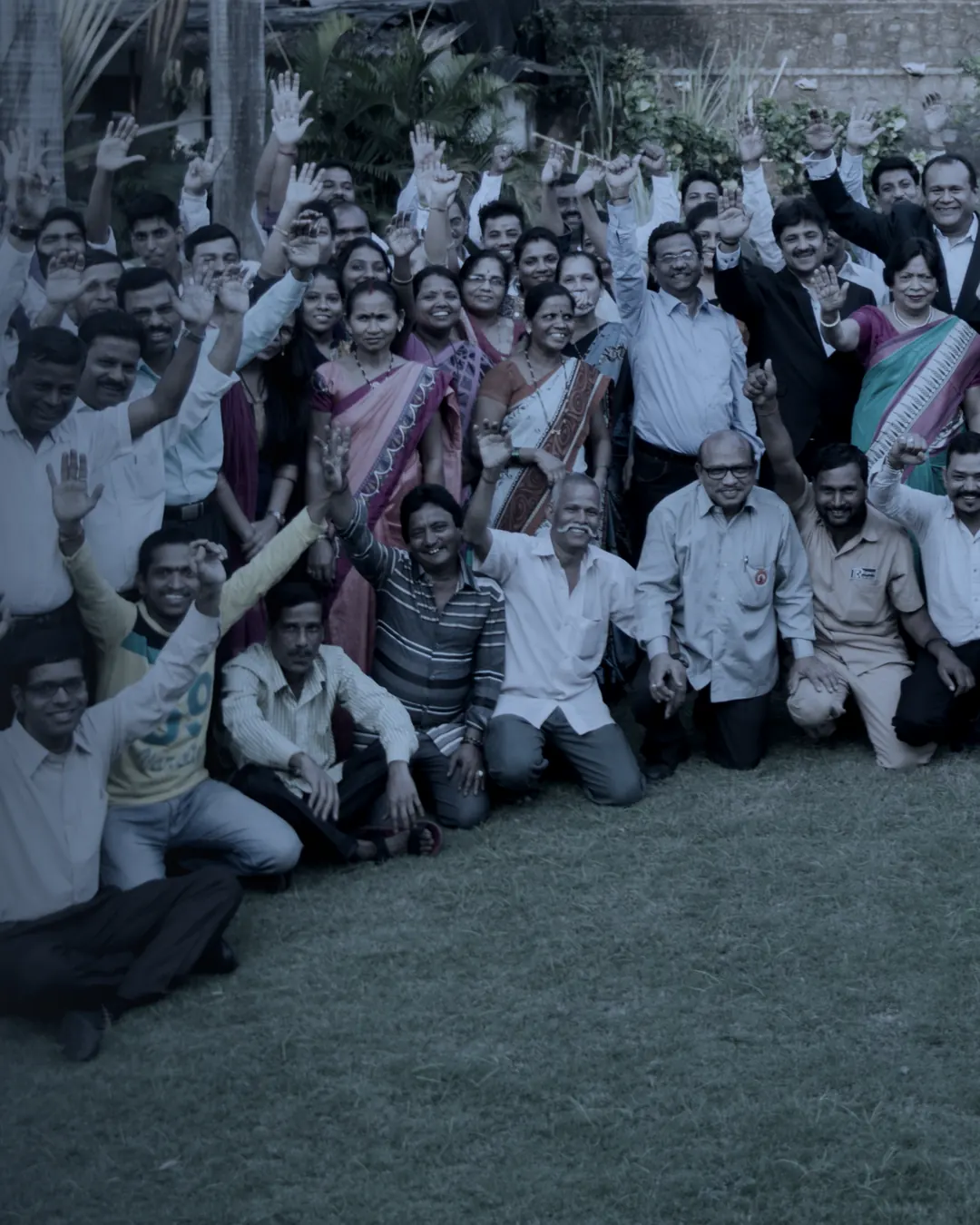 The TCR Engineering team photographed together on the lawn at Mahape, arms raised