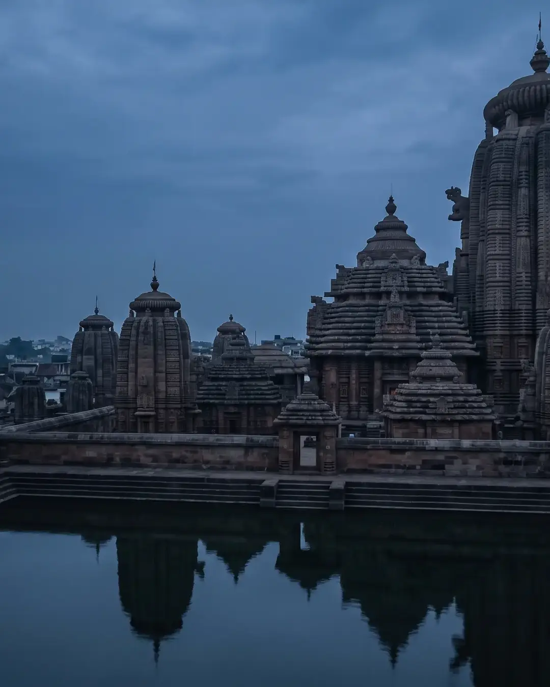 Bhubaneswar at blue hour: the Kalinga temple spires of the old city above a still temple tank