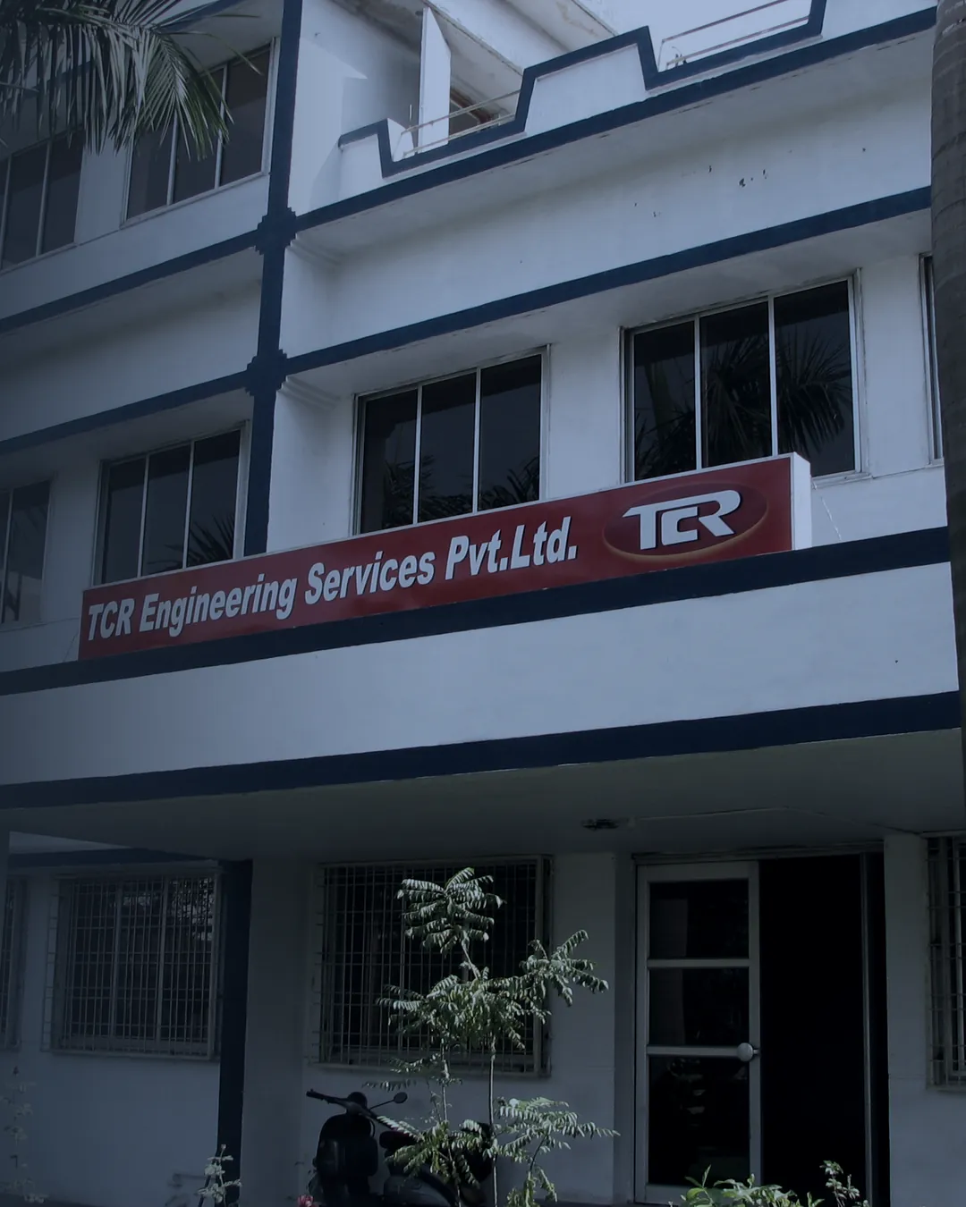 The TCR Engineering laboratory building at Mahape, Navi Mumbai, seen from the approach, with the company sign across the first floor