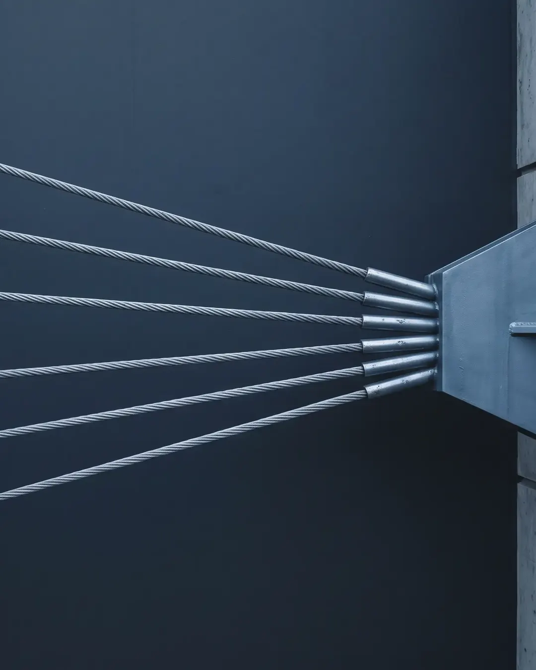 Six parallel steel cables under tension converging toward a single anchor point