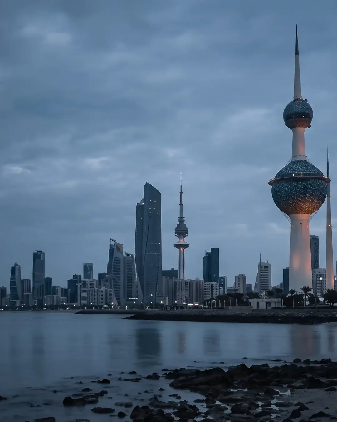 Kuwait City at blue hour: the Kuwait Towers on the Gulf shore with the city skyline behind